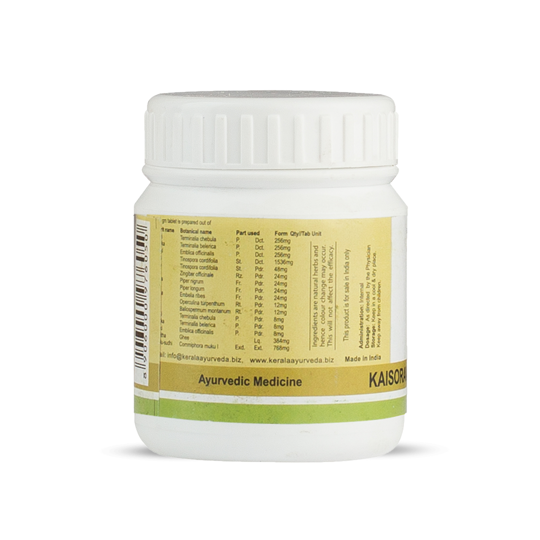 Side view of the Kaisora Gulgulu Gulika jar, showing a table of ingredients per tablet, including Terminalia chebula, Emblica officinalis, and Tinospora cordifolia, with quantities in mg. Dosage and storage information are visible. – Kerala Ayurveda India