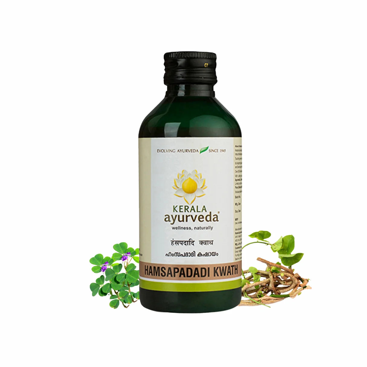 Front view of a dark green glass bottle of Kerala Ayurveda Hamsapadadi Kwath, with a white label displaying the product name in English and Malayalam script, along with the Kerala Ayurveda logo. It is surrounded by green leafy plants with purple flowers and dried roots. – Kerala Ayurveda India